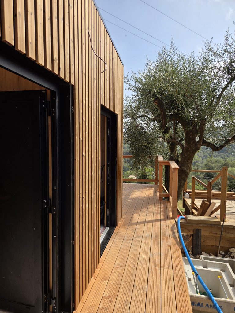 Façade en bardage vertical et terrasse en bois du cabanon