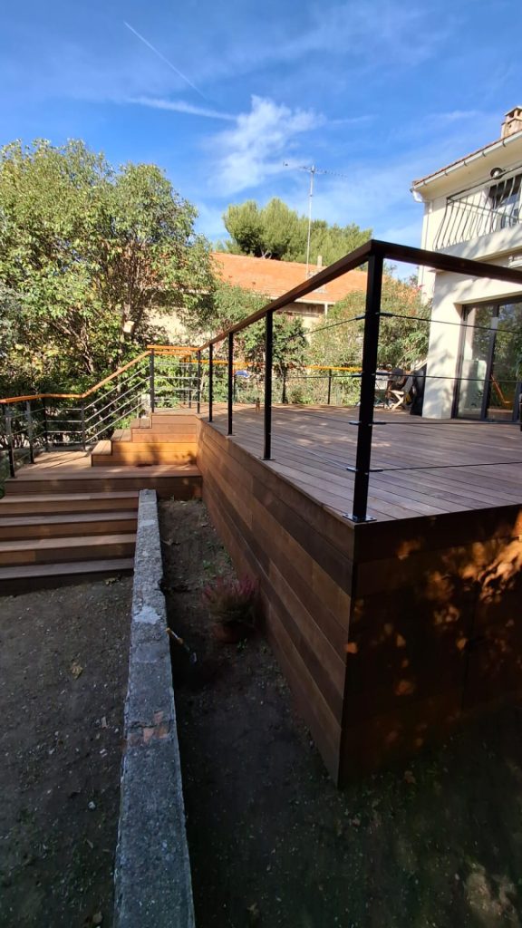 Terrasse surélevée en itauba avec habillage bois et garde-corps à câbles